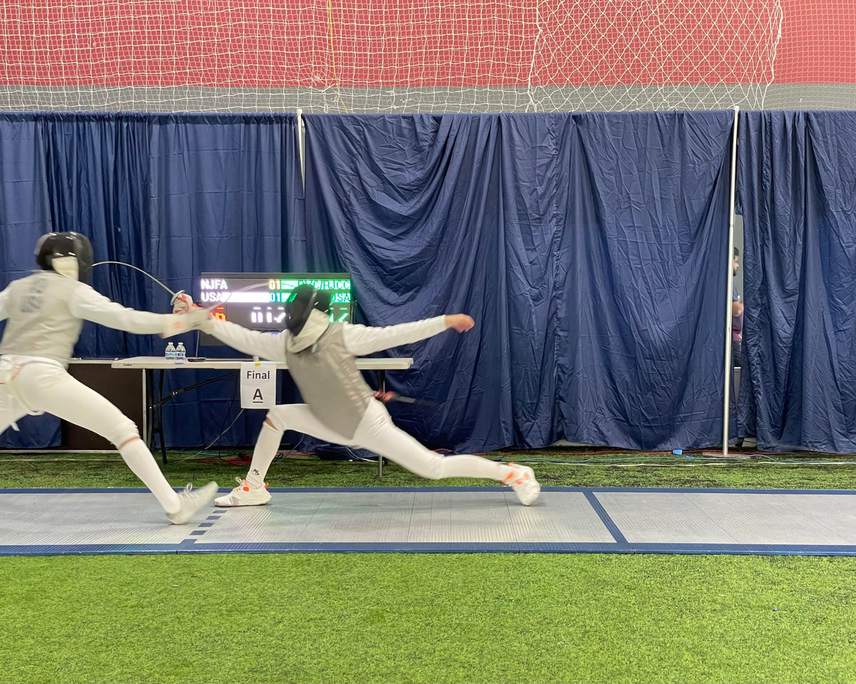 Two fencers in a lunge during a bout at NJFA